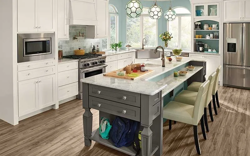 Kitchen with a grey island, seating for four and marble worktops
